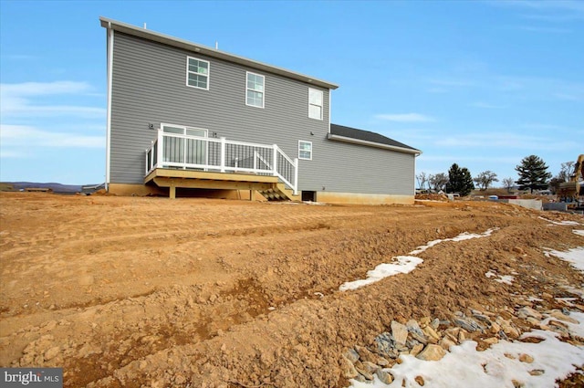 rear view of property featuring a wooden deck