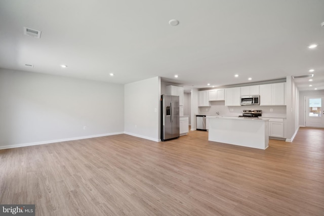 kitchen featuring white cabinetry, appliances with stainless steel finishes, a kitchen island, and light wood-type flooring