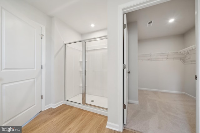 bathroom with wood-type flooring and an enclosed shower