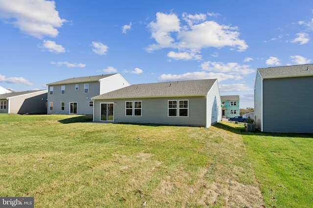 back of house featuring a lawn and central air condition unit