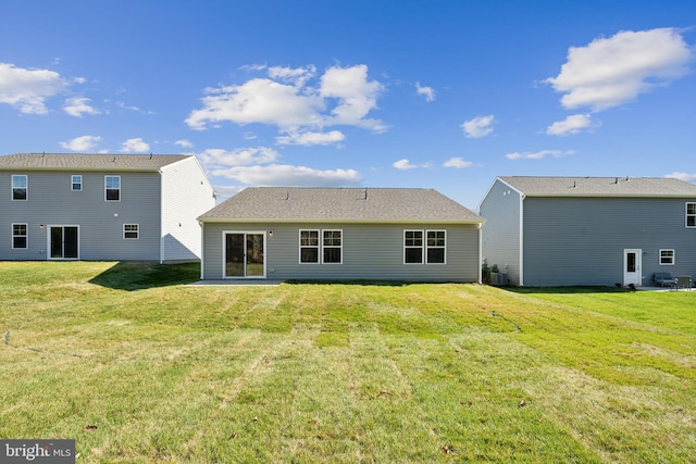 rear view of property featuring central AC and a yard