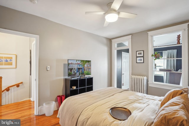 bedroom with radiator, ceiling fan, and hardwood / wood-style flooring