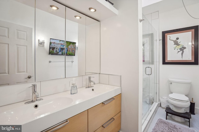 bathroom featuring a shower with shower door, toilet, and vanity