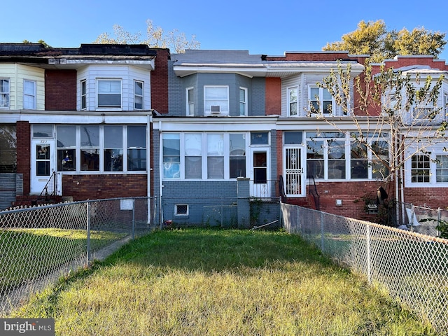 townhome / multi-family property featuring a front lawn and a sunroom