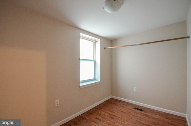 unfurnished room with wood-type flooring