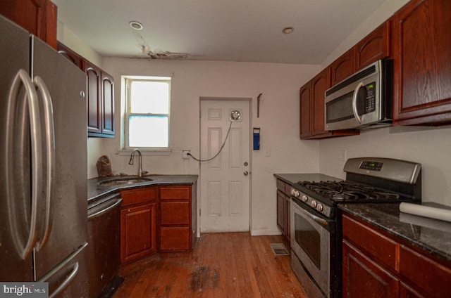 kitchen with dark wood-type flooring, appliances with stainless steel finishes, and sink