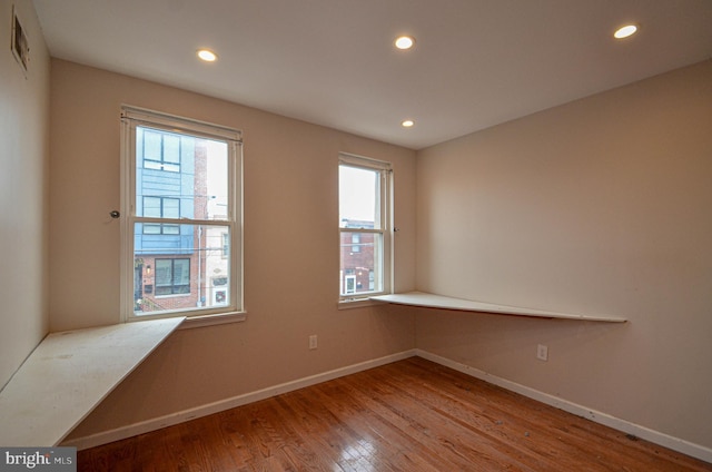 unfurnished room featuring a wealth of natural light and hardwood / wood-style flooring