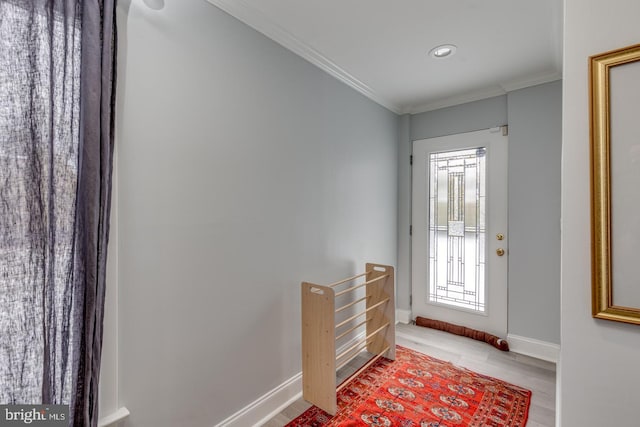 foyer entrance with light hardwood / wood-style floors and ornamental molding