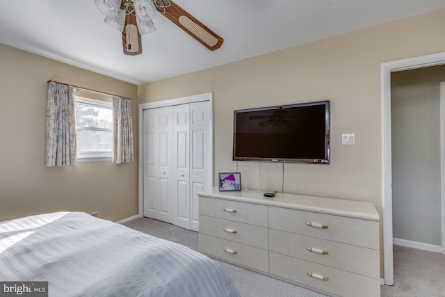 bedroom with a closet, ceiling fan, and light carpet