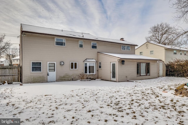 view of snow covered back of property