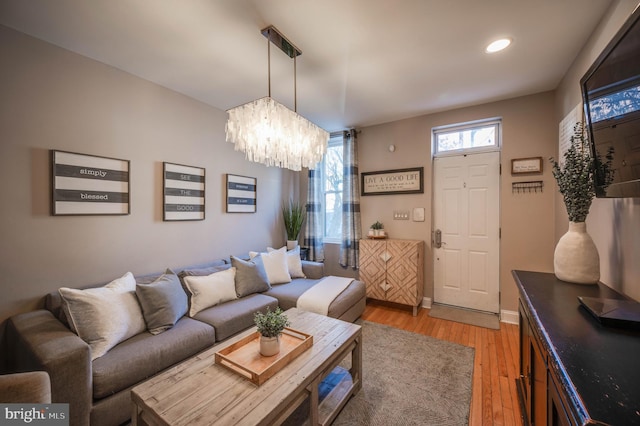 living room with a chandelier and light hardwood / wood-style floors