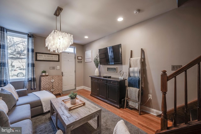 living room with light hardwood / wood-style floors and a chandelier