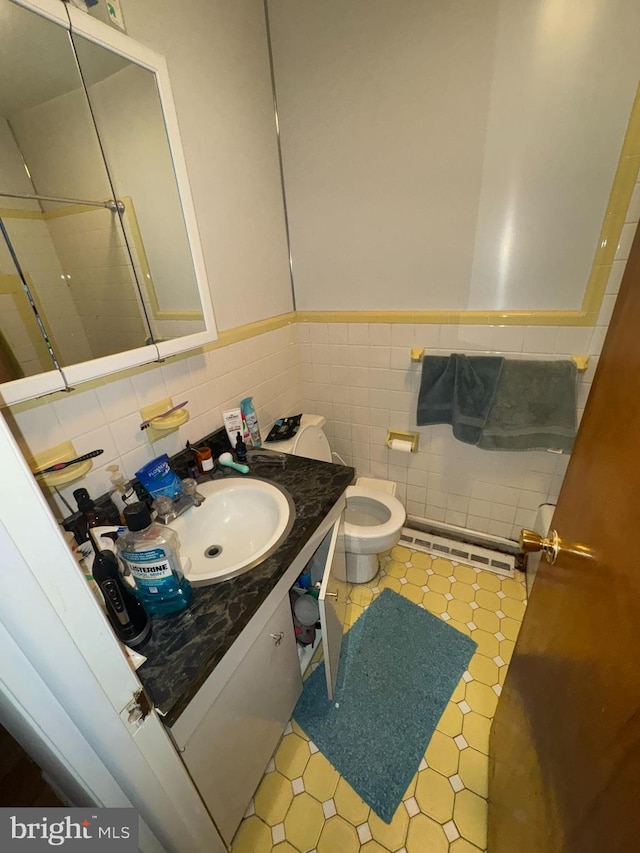 bathroom featuring toilet, vanity, and a baseboard radiator