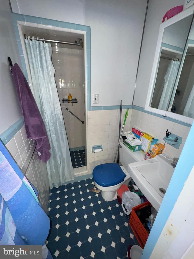 bathroom with sink, tile walls, toilet, and a shower with curtain