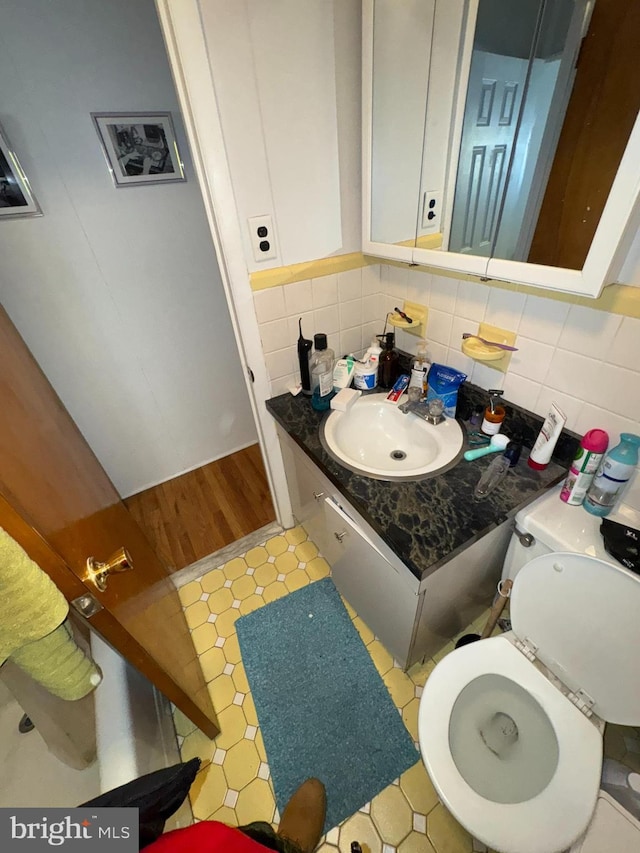 bathroom with tasteful backsplash, vanity, and toilet