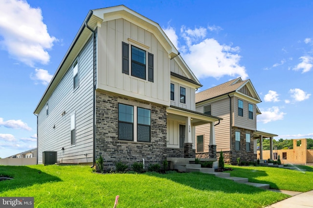 view of front of property with a front yard, covered porch, and central AC unit