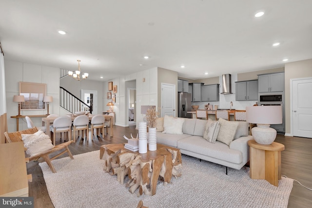 living room featuring an inviting chandelier, hardwood / wood-style flooring, and sink