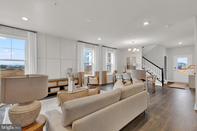 living room with dark hardwood / wood-style floors and a notable chandelier