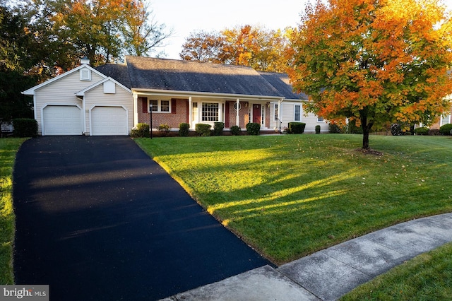 single story home with a garage, a front yard, and covered porch