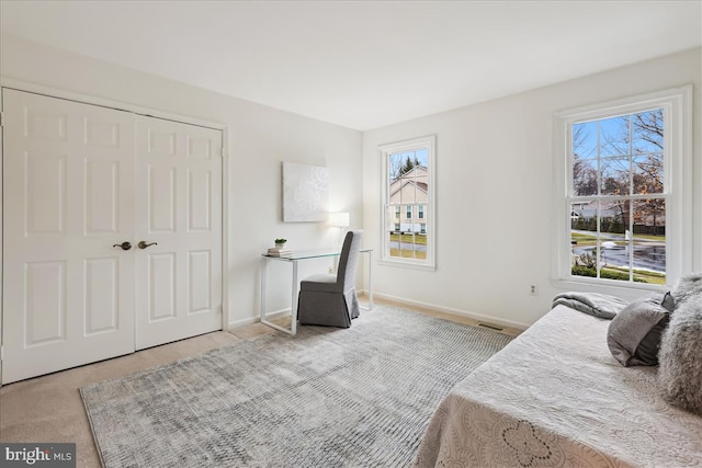 bedroom featuring light carpet and a closet