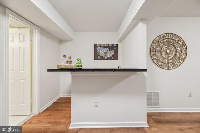 interior space featuring bar and hardwood / wood-style flooring