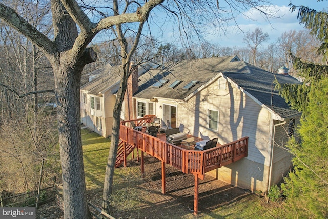 rear view of property featuring a yard and a deck