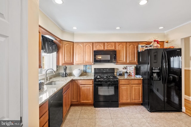 kitchen with sink, light tile patterned floors, ornamental molding, black appliances, and light stone countertops