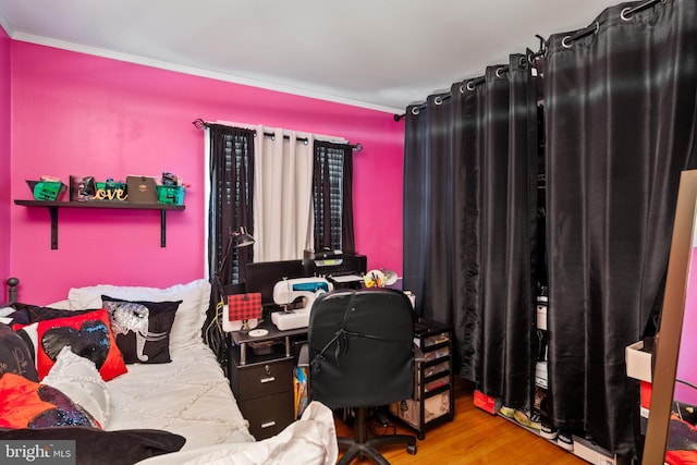 bedroom with hardwood / wood-style floors and ornamental molding