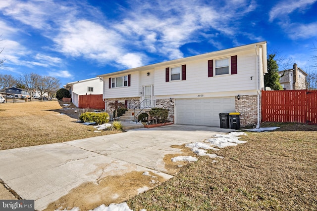 split foyer home with a garage and a front lawn