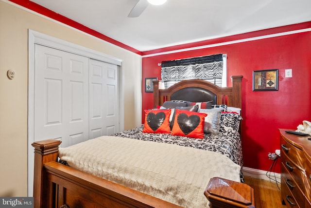 bedroom with dark hardwood / wood-style floors, ceiling fan, and a closet