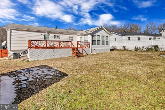 back of property with a wooden deck and a yard