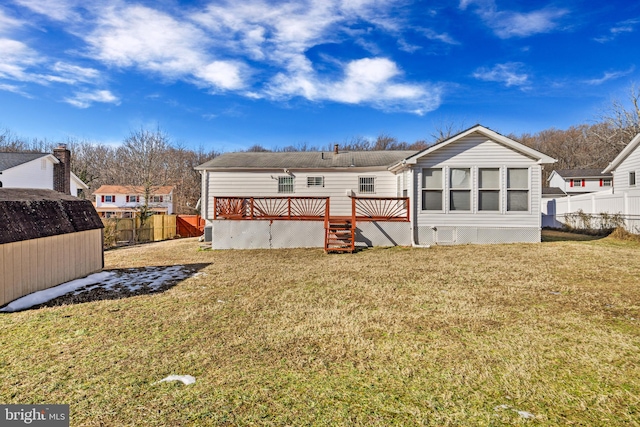 back of property with a shed, a deck, and a lawn