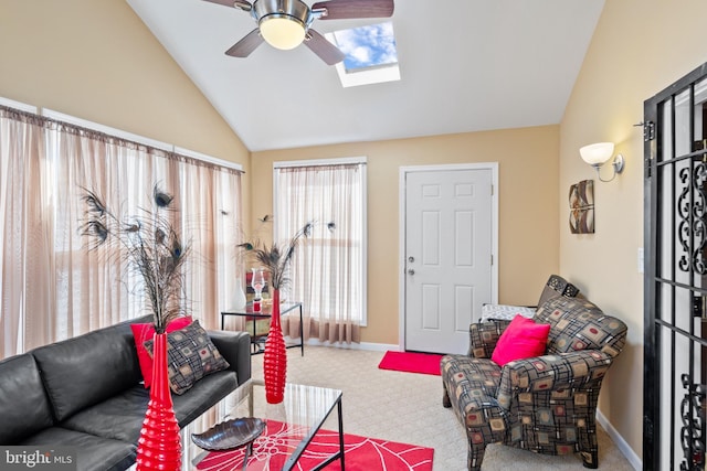 carpeted living room featuring ceiling fan and vaulted ceiling with skylight