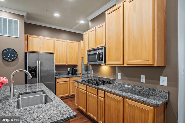 kitchen featuring sink, a kitchen island with sink, stainless steel appliances, ornamental molding, and dark stone counters