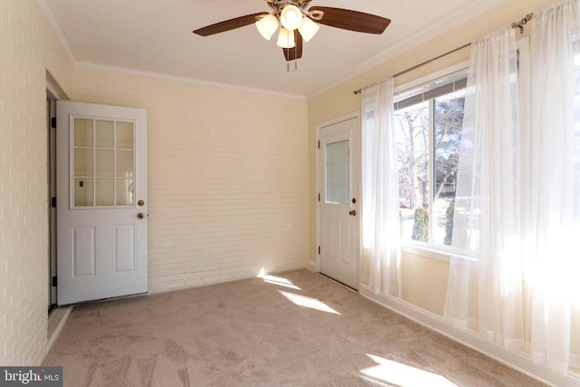 interior space with ornamental molding, brick wall, light colored carpet, and ceiling fan