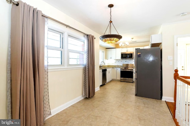 kitchen featuring white cabinetry, sink, decorative backsplash, hanging light fixtures, and stainless steel appliances