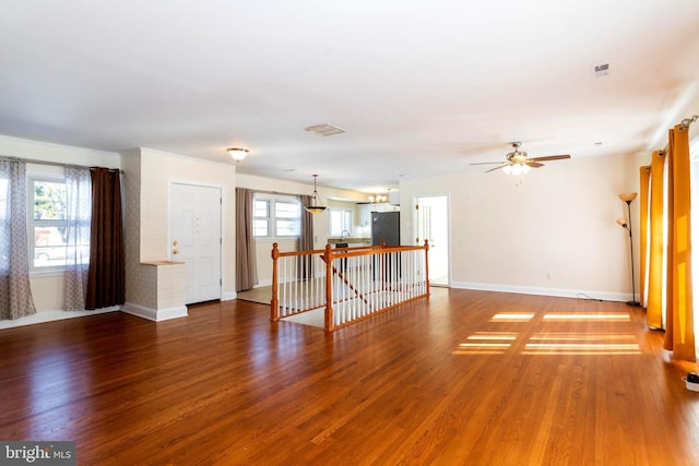 unfurnished living room featuring dark hardwood / wood-style flooring and ceiling fan