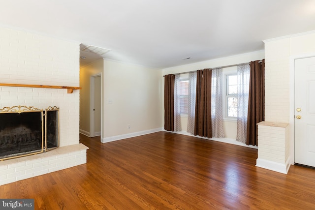 unfurnished living room with crown molding, a brick fireplace, and hardwood / wood-style flooring