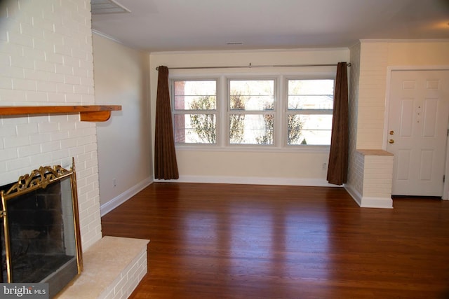 unfurnished living room with dark hardwood / wood-style flooring, a brick fireplace, and ornamental molding