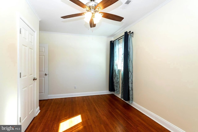 empty room featuring dark wood-type flooring, ornamental molding, and ceiling fan