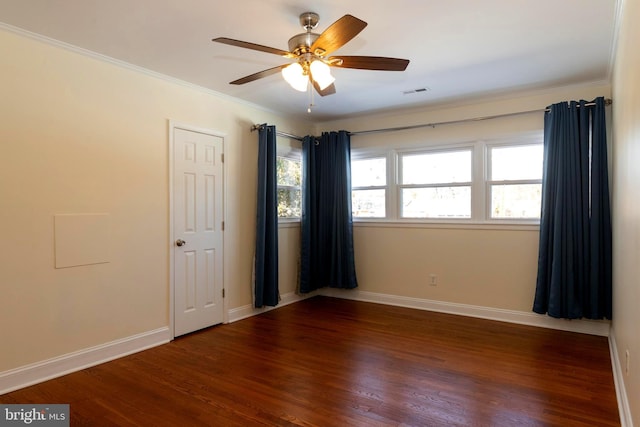 empty room with crown molding, ceiling fan, and dark hardwood / wood-style flooring