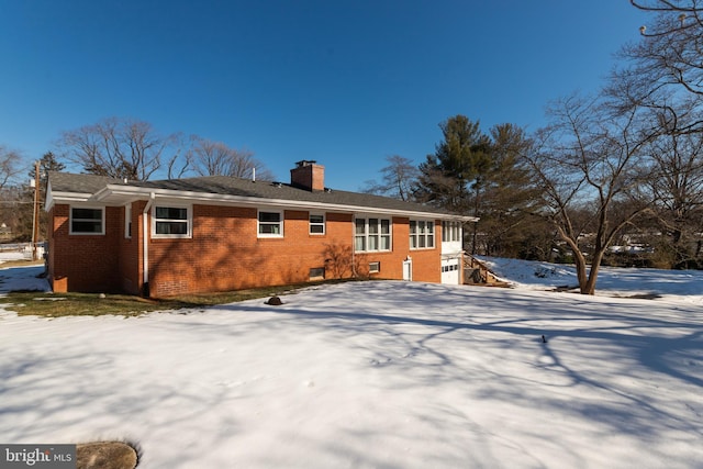 view of snow covered back of property