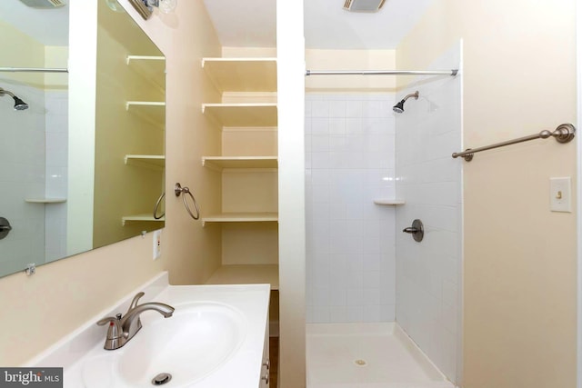 bathroom with sink and a tile shower