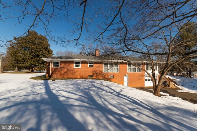 view of snow covered rear of property