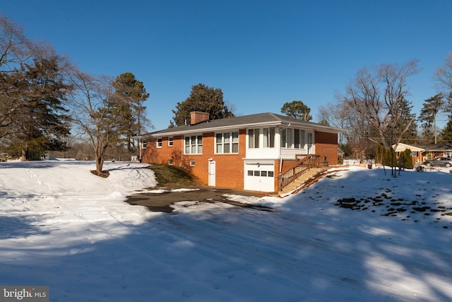 snow covered property with a garage