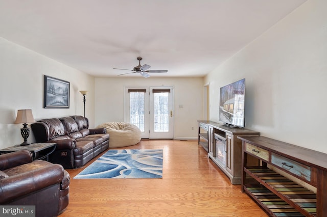 living room featuring ceiling fan and light wood-type flooring