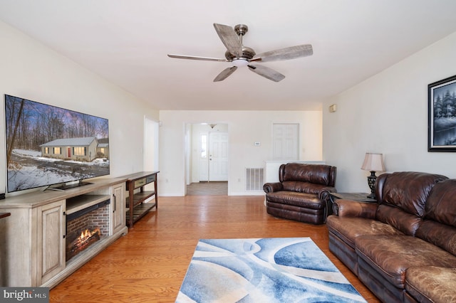 living room with ceiling fan and light wood-type flooring