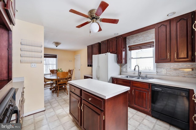 kitchen featuring sink, a wealth of natural light, black dishwasher, and white refrigerator