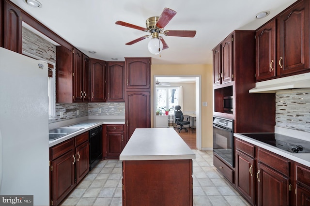 kitchen with sink, tasteful backsplash, a kitchen island, ceiling fan, and black appliances