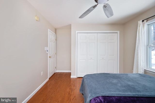 bedroom with hardwood / wood-style flooring, ceiling fan, and a closet